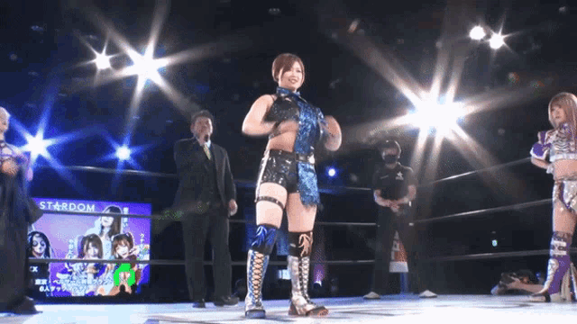 a woman stands in a wrestling ring with a stardom sign behind her