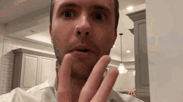 a man in a white shirt is making a funny face
