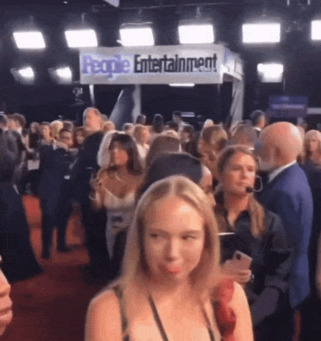 a crowd of people gathered in front of a people entertainment sign