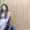 a woman in a white dress is sitting in a blue chair .