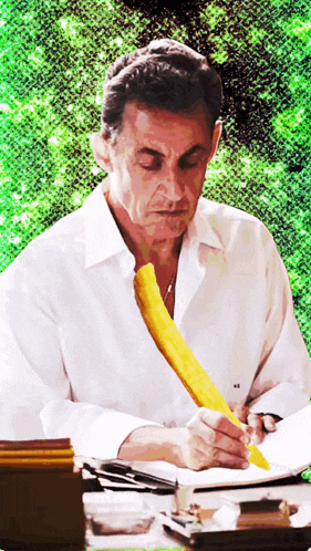 a man in a white shirt with a yellow tie is writing