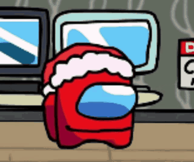 a red among us character wearing a santa hat is sitting in front of a computer .