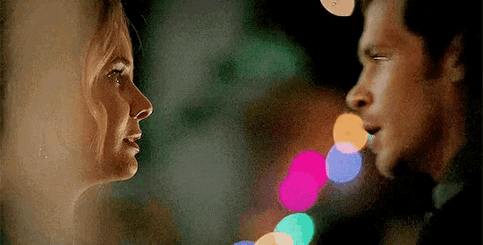 a man and a woman are looking at each other in a blurry photo