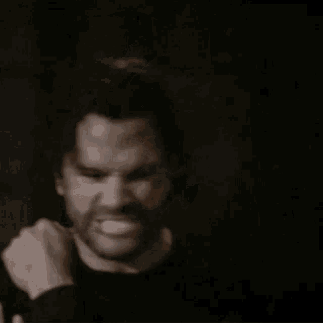 a man with a beard is being strangled by a woman .