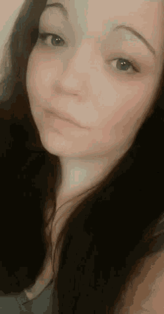 a woman with long dark hair is taking a selfie