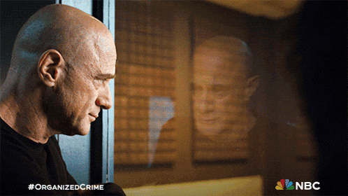 an advertisement for organized crime shows a bald man looking at his reflection
