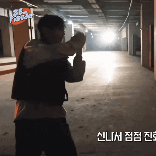 a man stands in a dark room with a sign that says ' be a pisode ' on it