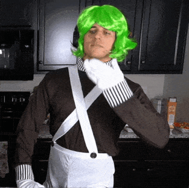 a man in a green wig and white gloves stands in a kitchen next to a box of orange juice