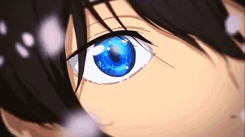 a close up of a person 's blue eye with a black background .