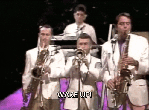 a group of men are playing instruments and the words wake up are on the screen