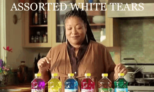 a woman in a kitchen with bottles of assorted white tears on the counter