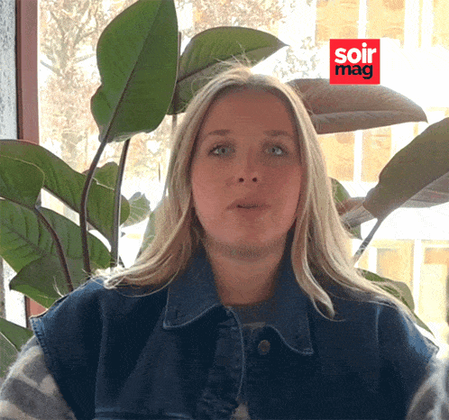 a woman is sitting in front of a plant with a soir mag logo in the corner