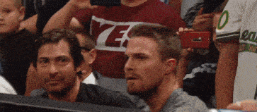 a man taking a picture of another man in a crowd while wearing a shirt that says ye