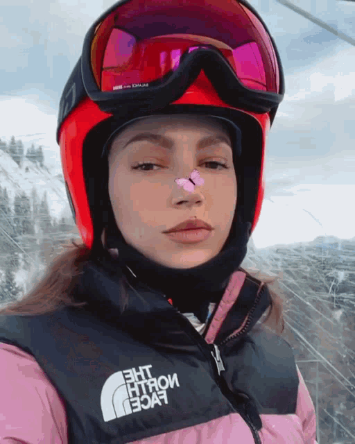 a woman wearing a helmet and a vest with the north face on it