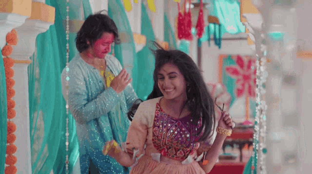 a woman in a pink dress is dancing with a man in a blue dress