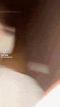 a tiktok video of a person wearing a white shirt and a mask