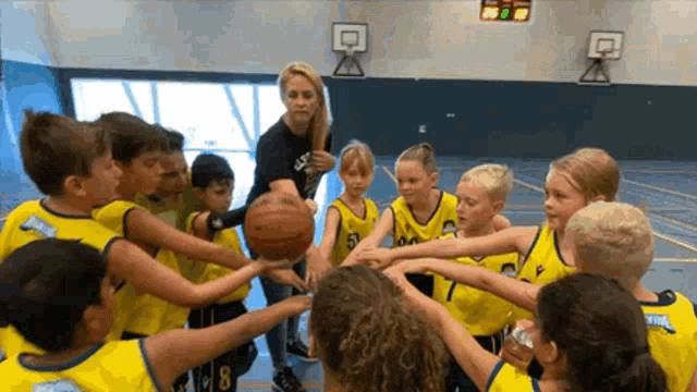 a group of kids are huddled around a basketball with one wearing the number 8