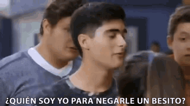 a group of young men are standing next to each other and one of them is asking a question in spanish .