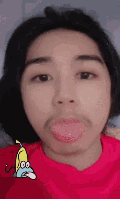 a close up of a person 's face with a cartoon of a banana sticking out its tongue