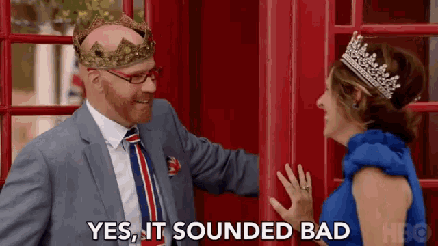 a man wearing a crown is standing next to a woman wearing a blue dress and tiara .