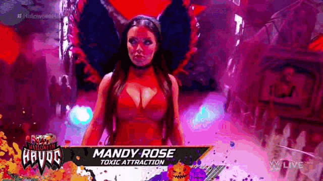 a woman in a red dress and black wings is standing in front of a sign that says mandy rose toxic attraction .