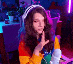 a woman wearing headphones is sitting in front of a microphone and talking into it .