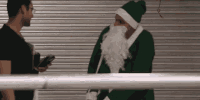 a man in a santa costume talks to another man