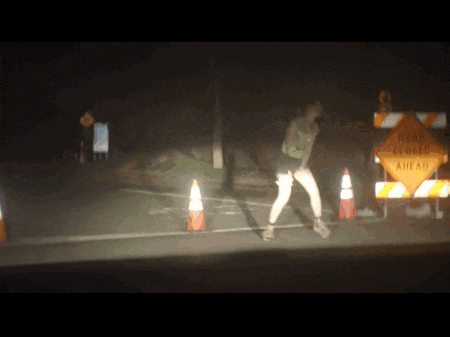 a woman stands in front of a road closed sign