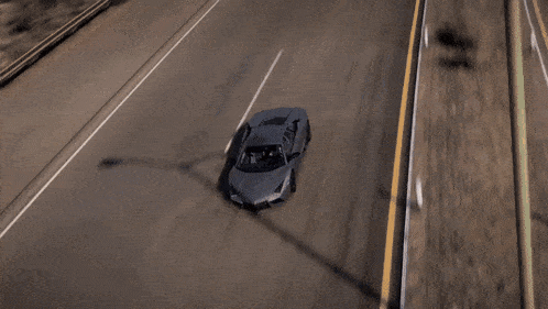 a gray car is driving down a highway with a yellow line