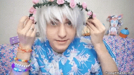 a boy wearing a flower crown and a blue shirt
