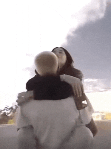 a man is carrying a woman on his shoulders in a video .