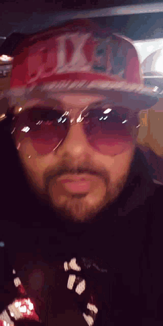 a man wearing sunglasses and a red hat that says fox
