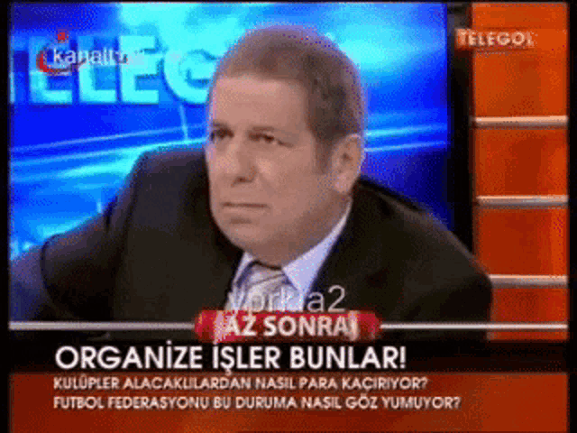 a man in a suit and tie is talking on a tv show called telegol
