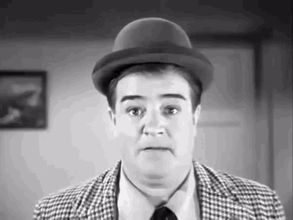 a black and white photo of a man wearing a bowler hat and a plaid jacket .