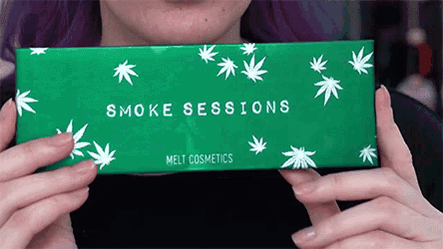 a woman is holding a green box that says smoke sessions on it
