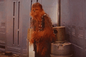 a chewbacca standing next to a trash can in a room