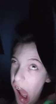 a young girl is making a funny face with her mouth open .
