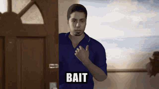 a man in a blue shirt is standing in front of a door with the word bait written above him