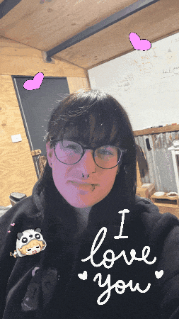 a woman wearing glasses and a black hoodie with the words i love you written on it