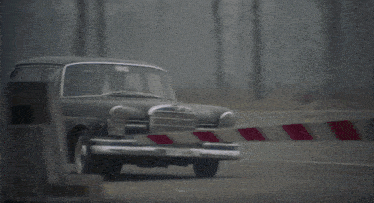 a car is being towed by a red and white striped object