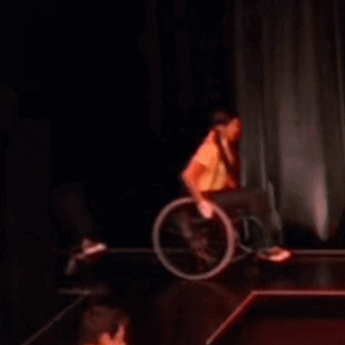 a man in a wheelchair is dancing on stage