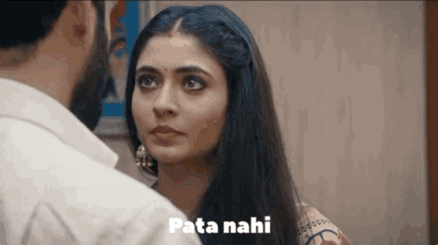 a man and a woman are looking at each other with the words pata nahi written above them .