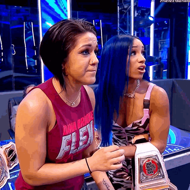 a woman with blue hair is wearing a dana brooks shirt
