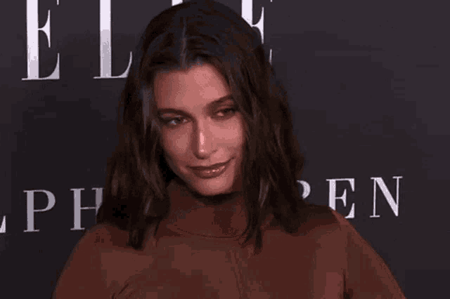 a woman is smiling while standing on a red carpet in front of a sign that says elle