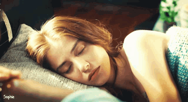 a woman is sleeping in a bed with the name sophie on the bottom right