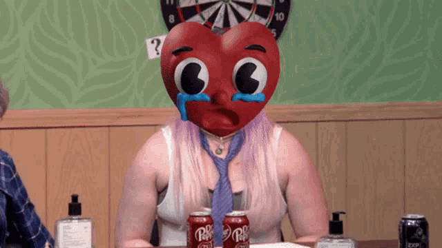 a woman wearing a heart shaped mask with tears running down her face