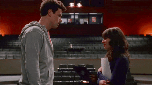 a man and a woman are standing in front of an auditorium