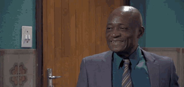 a man in a suit and tie is smiling