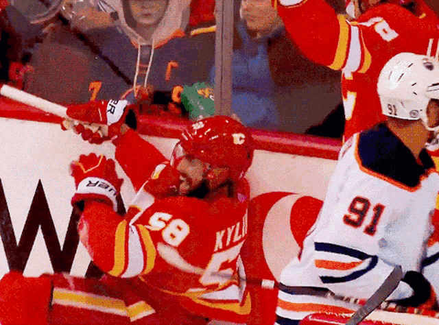 a hockey player with the number 58 on his back is falling