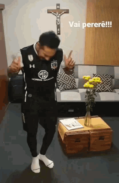 a man in a black under armour shirt is dancing in front of a cross